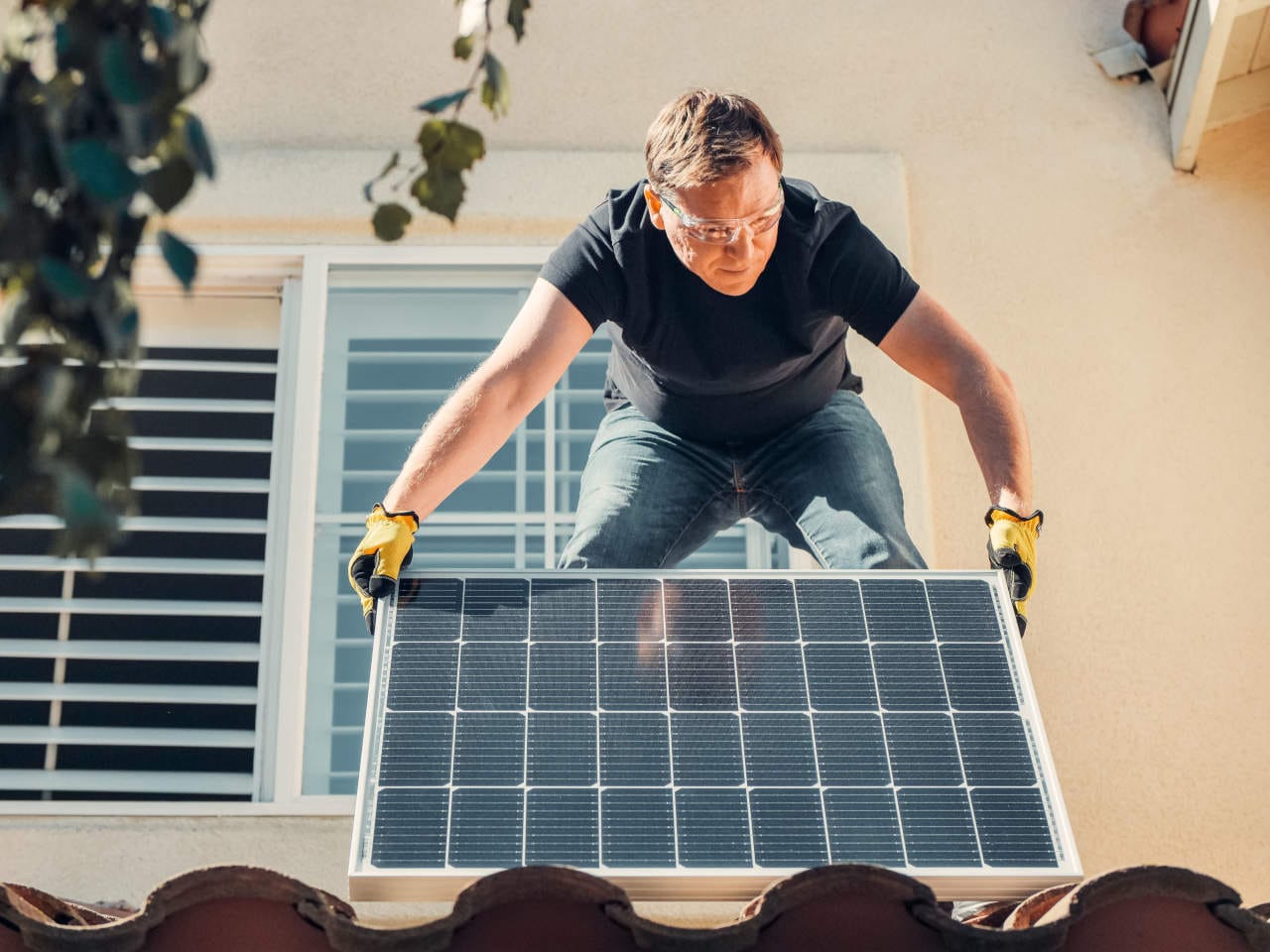 House with rooftop solar panels generating electricity as an alternative to grid power