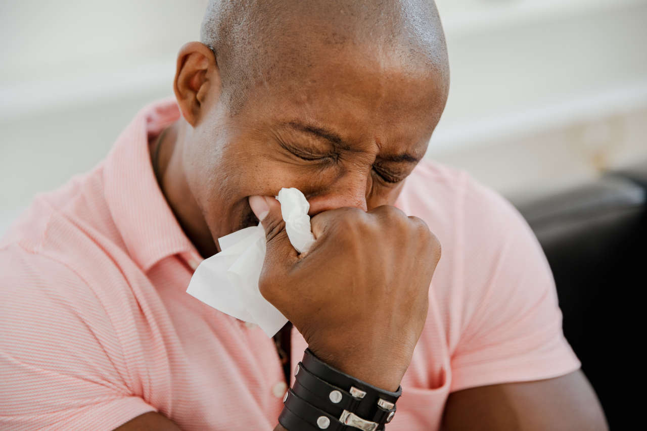 Distressed man holding a tissue to his face, illustrating the emotional impact of losing irreplaceable files and family photographs.