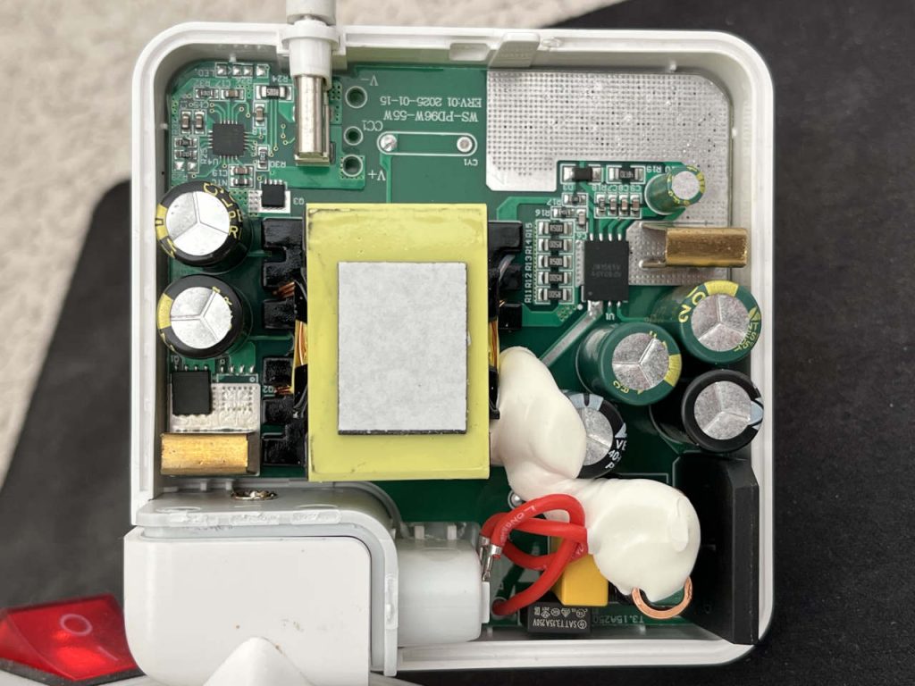 Internal circuit board of a no-name 87W USB-C MacBook charger with transformer, capacitors and power components.