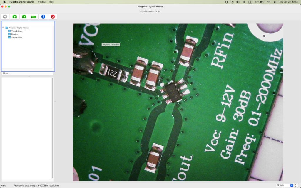 PCB viewed through the Plugable digital microscope at lower magnification, showing an IC and surrounding SMD components.