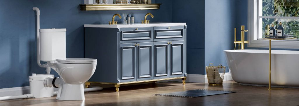 Elegant blue bathroom with a white toilet connected to a macerating pump, double-sink vanity with gold fixtures, and freestanding bathtub.